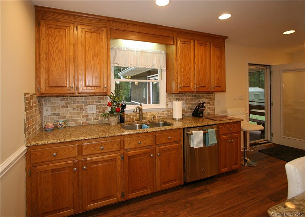9505 Mini Ranch Road Waxhaw, NC 28173 - Photo 9 of 24 a kitchen with stainless steel appliances granite countertop wooden cabinets a sink and dishwasher with wooden floor