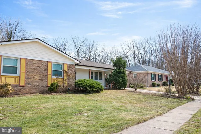 a front view of house with yard and trees around