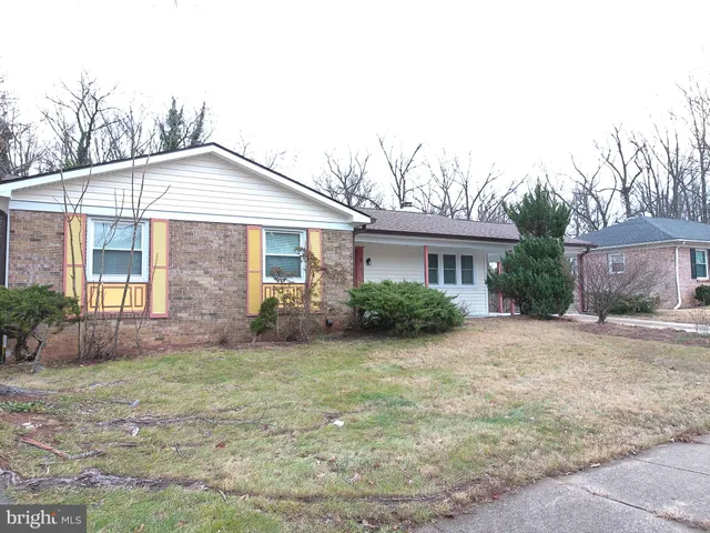 a front view of a house with a yard and potted plants