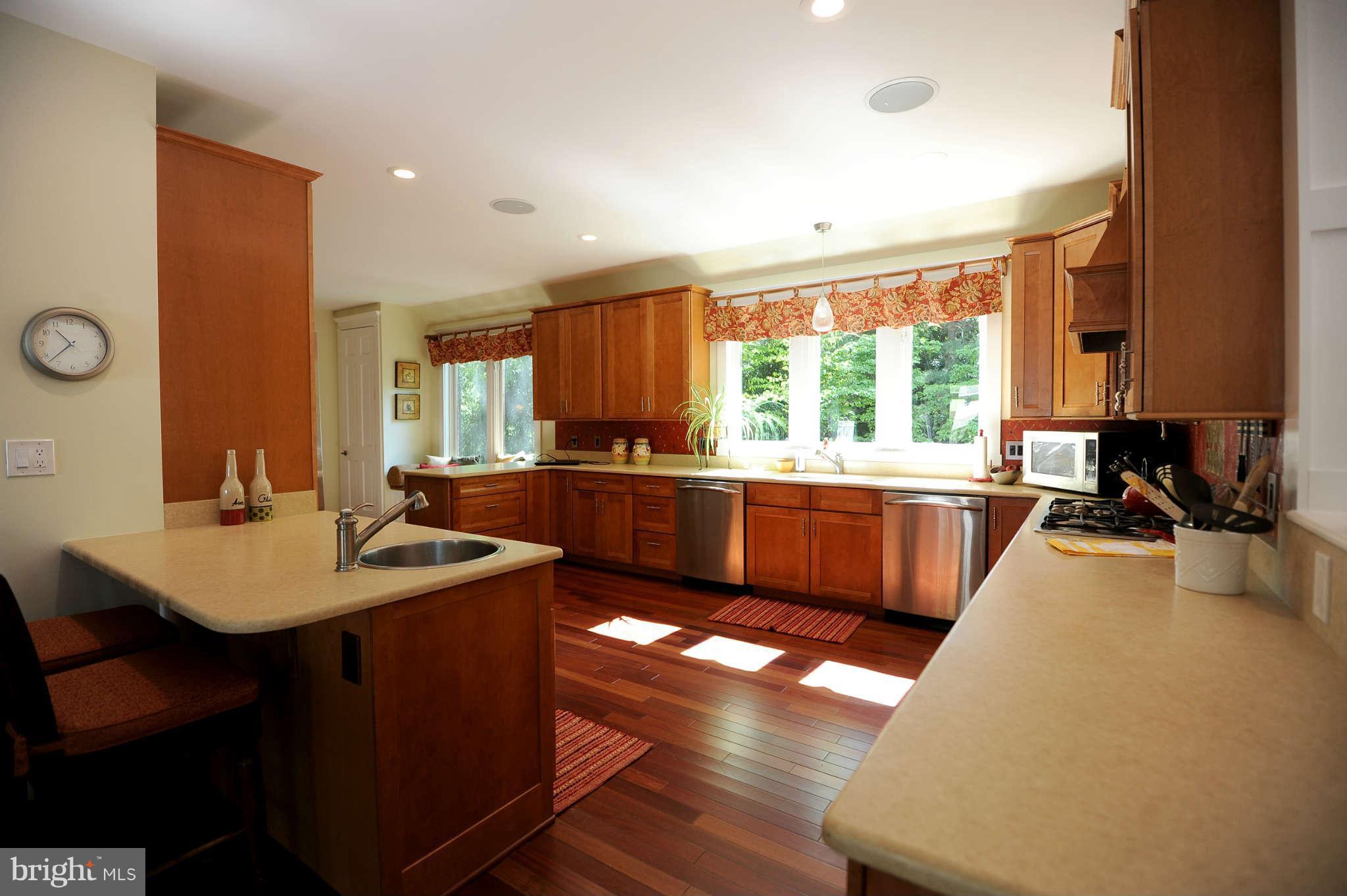 2013 Rockingham Street McLean, VA 22101 - Photo 7 of 30 a large kitchen with kitchen island a sink a counter top space a large window and stainless steel appliances