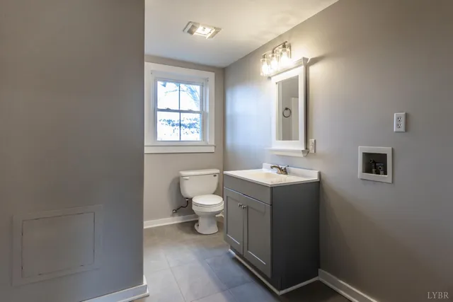 a bathroom with a sink toilet and mirror