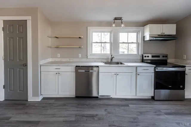 a kitchen with stainless steel appliances a sink stove and cabinets