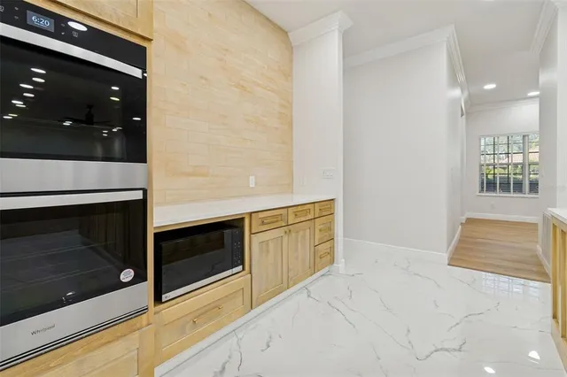 a view of empty room with wooden floor and a kitchen