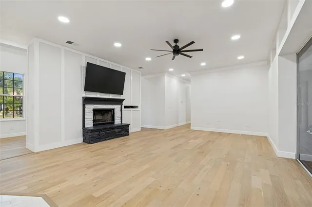 a view of an empty room with a window and a ceiling fan