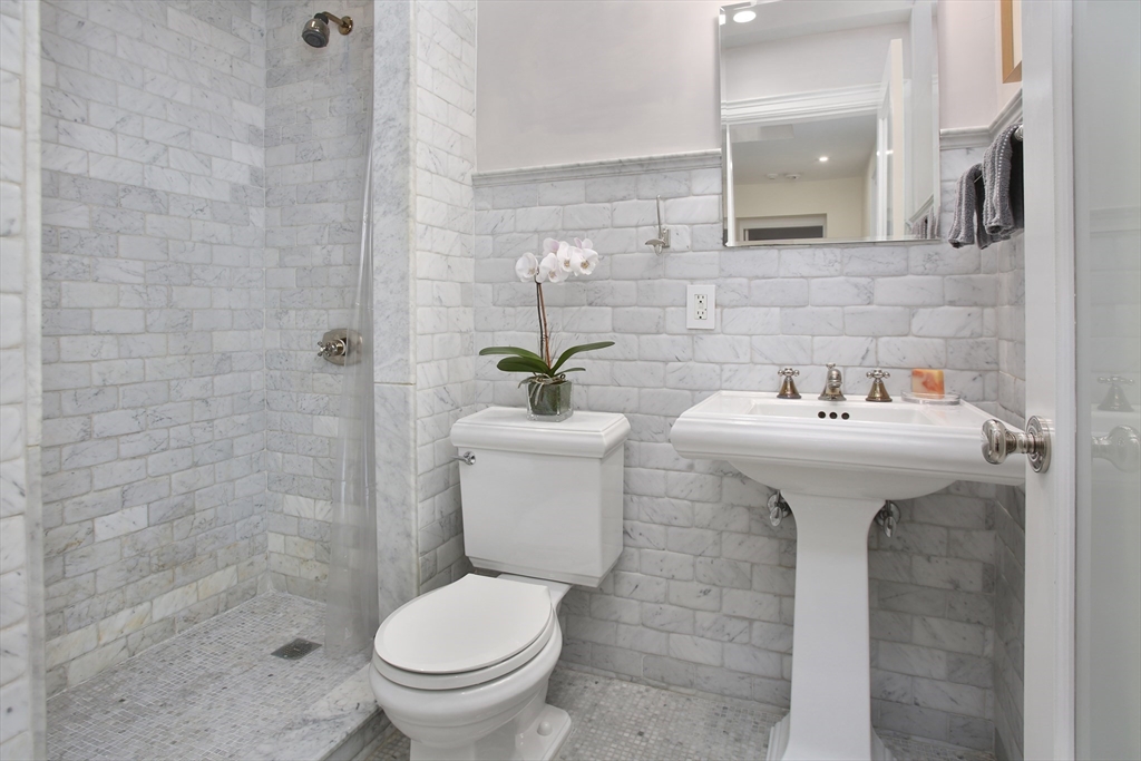 615 Massachusetts Avenue, Unit 2 Boston, MA 02118 - Photo 13 of 32 a bathroom with a sink toilet and a mirror