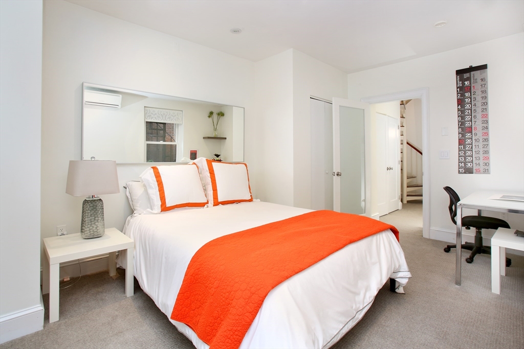 615 Massachusetts Avenue, Unit 2 Boston, MA 02118 - Photo 30 of 32 a bedroom with bed and a table in it