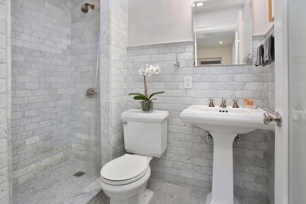 615 Massachusetts Avenue, Unit 2 Boston, MA 02118 - Photo 32 of 32 a bathroom with a sink toilet and a mirror