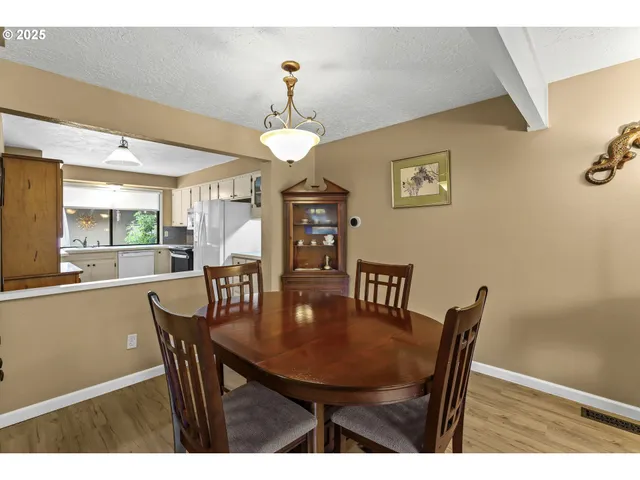 a view of a dining room with furniture a chandelier and wooden floor