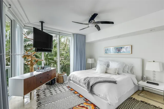 a bedroom with a large bed and a flat tv screen