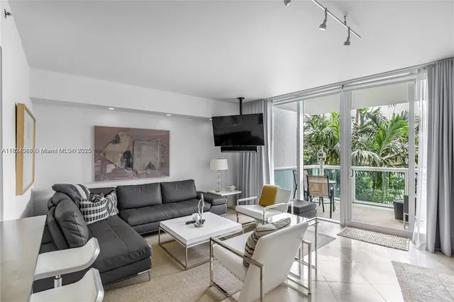 a living room with furniture a flat screen tv and a large window