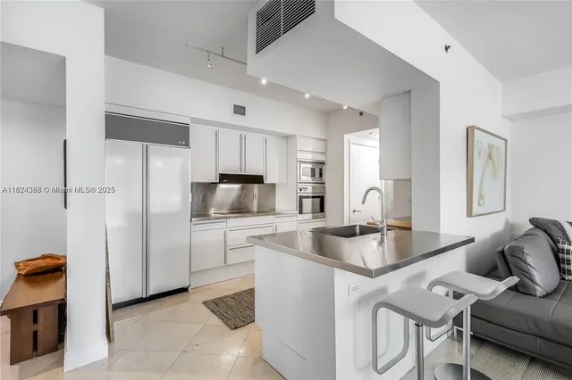 a kitchen with stainless steel appliances granite countertop a sink refrigerator and cabinets