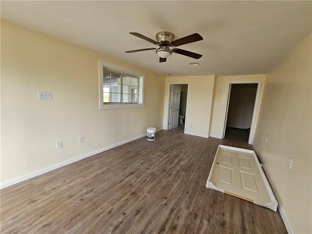 a view of a livingroom with wooden floor and a ceiling fan