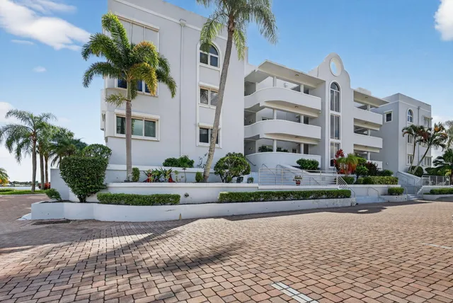 a front view of multi story residential apartment building with yard and green space