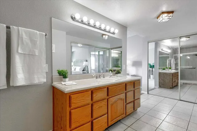 a bathroom with a granite countertop sink a mirror and a shower