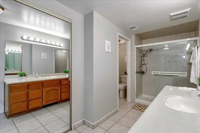 a bathroom with a double vanity sink mirror and shower