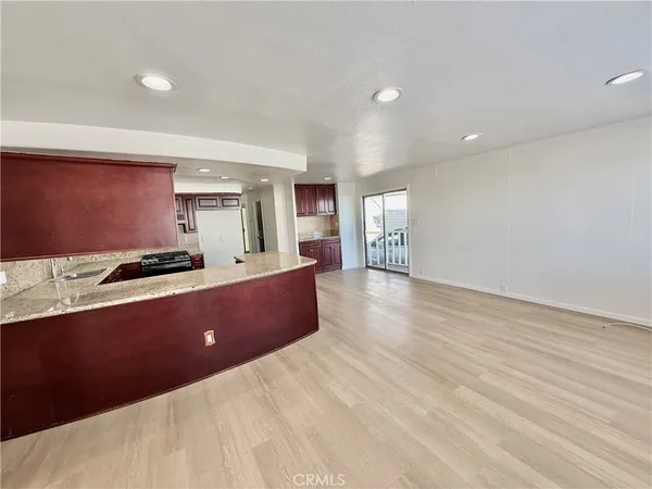 a living room with stainless steel appliances kitchen island granite countertop furniture and a large window