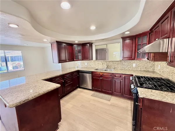 a kitchen with stainless steel appliances granite countertop a stove a sink and a refrigerator