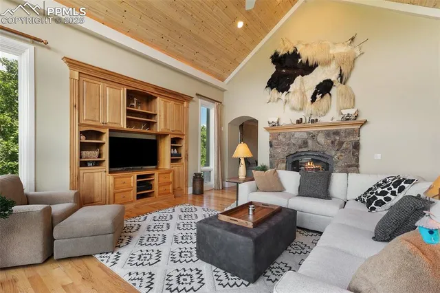 a kitchen with stainless steel appliances kitchen island granite countertop wooden floors and a view of living room