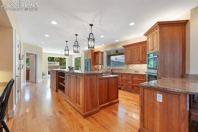 a kitchen with stainless steel appliances kitchen island granite countertop a refrigerator a stove top oven and sink