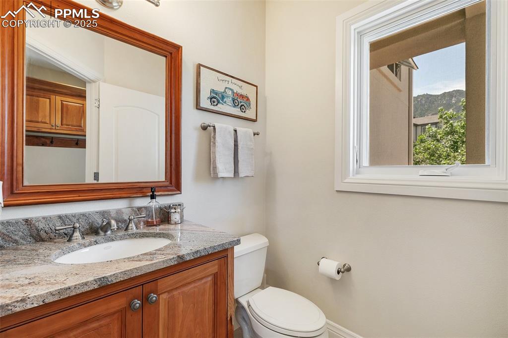 4490 Star Ranch Road Colorado Springs, CO 80906 - Photo 20 of 50 a bathroom with a granite countertop toilet sink and mirror
