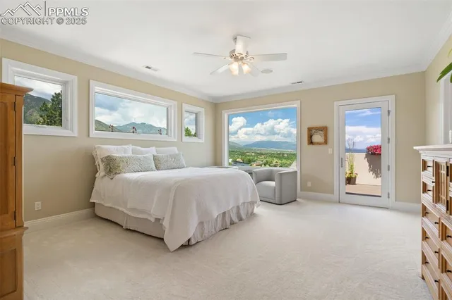 a spacious bedroom with a bed a dresser and a chandelier
