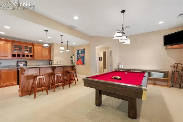 a room with pool table and windows