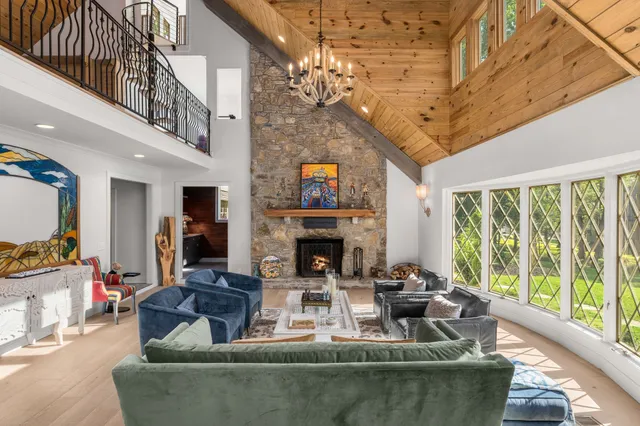 a living room with furniture a wooden floor and kitchen view