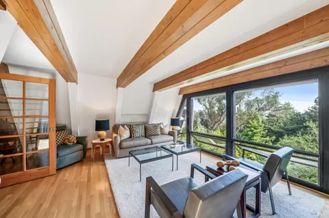 a living room with furniture and floor to ceiling windows