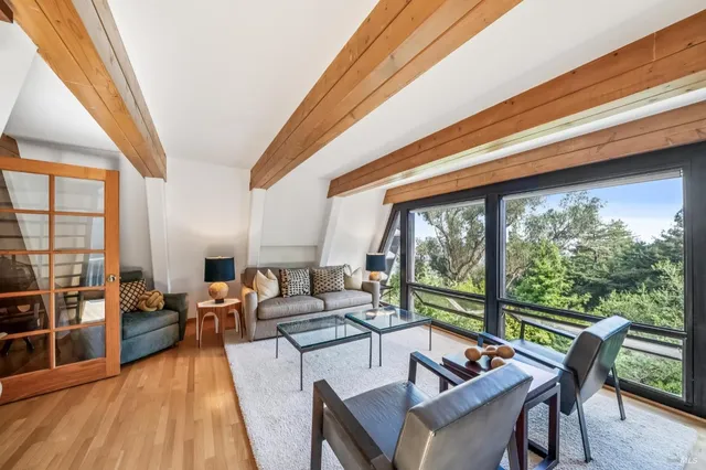 a living room with furniture and floor to ceiling windows