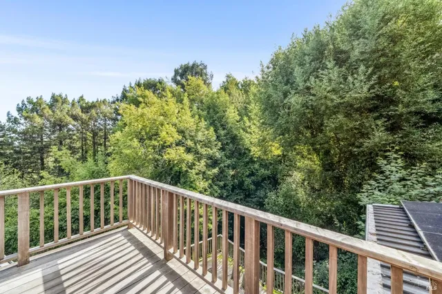 a wooden deck with trees in front of it