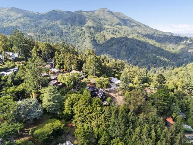 a view of a houses with a lush green hillside
