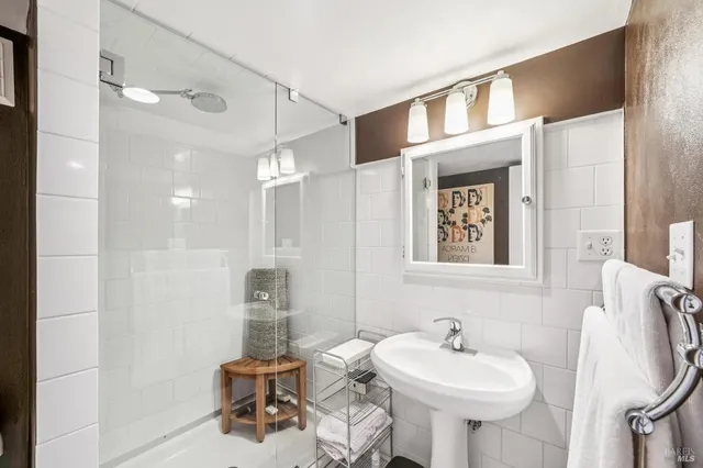 a bathroom with a sink a mirror and a shower