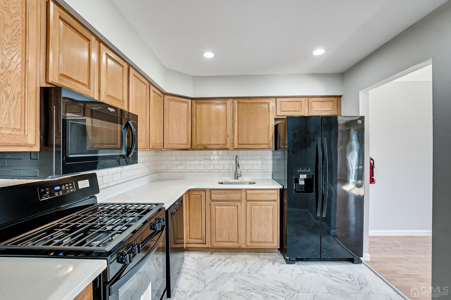 6308 Hana Road Edison, NJ 08817 - Photo 5 of 35 a kitchen with stainless steel appliances granite countertop a refrigerator and a stove top oven