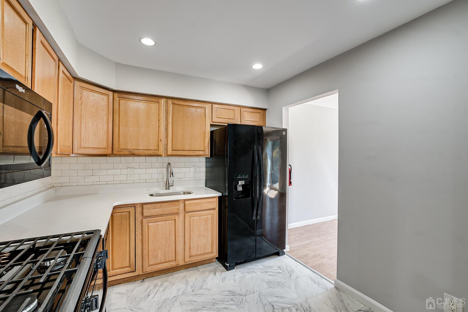 6308 Hana Road Edison, NJ 08817 - Photo 9 of 35 a kitchen with a refrigerator and a sink