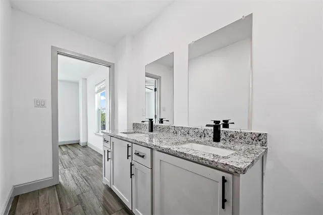 a bathroom with a granite countertop sink and a mirror