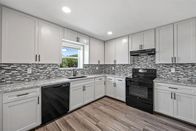 a kitchen with granite countertop cabinets stainless steel appliances and a sink