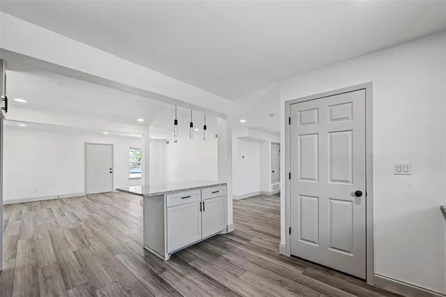 a view of a kitchen with wooden floor and cabinets