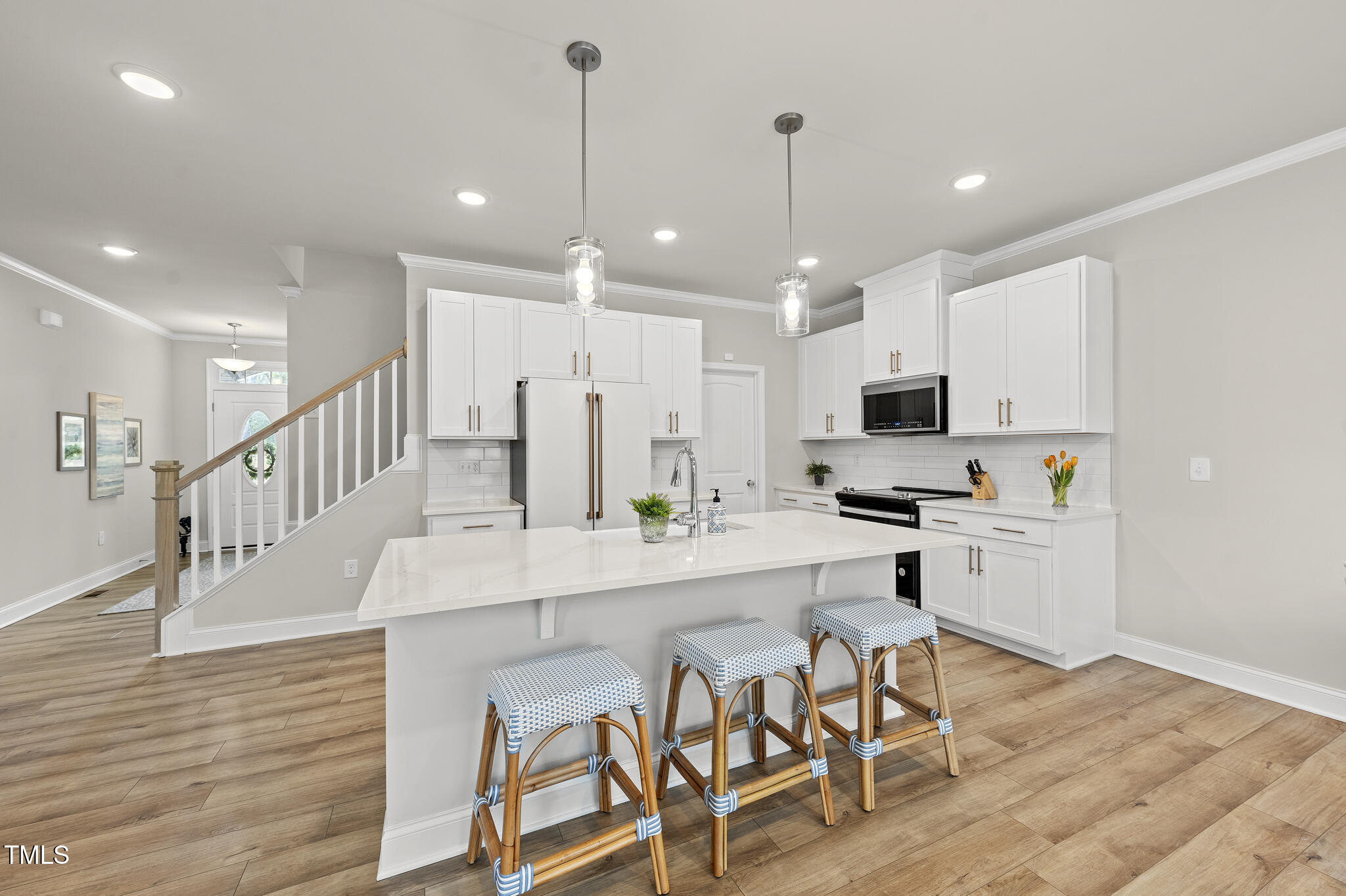 111 Kim Bark Path Garner, NC 27529 - Photo 19 of 52 a kitchen with stainless steel appliances kitchen island granite countertop a stove a sink a refrigerator and white cabinets with wooden floor