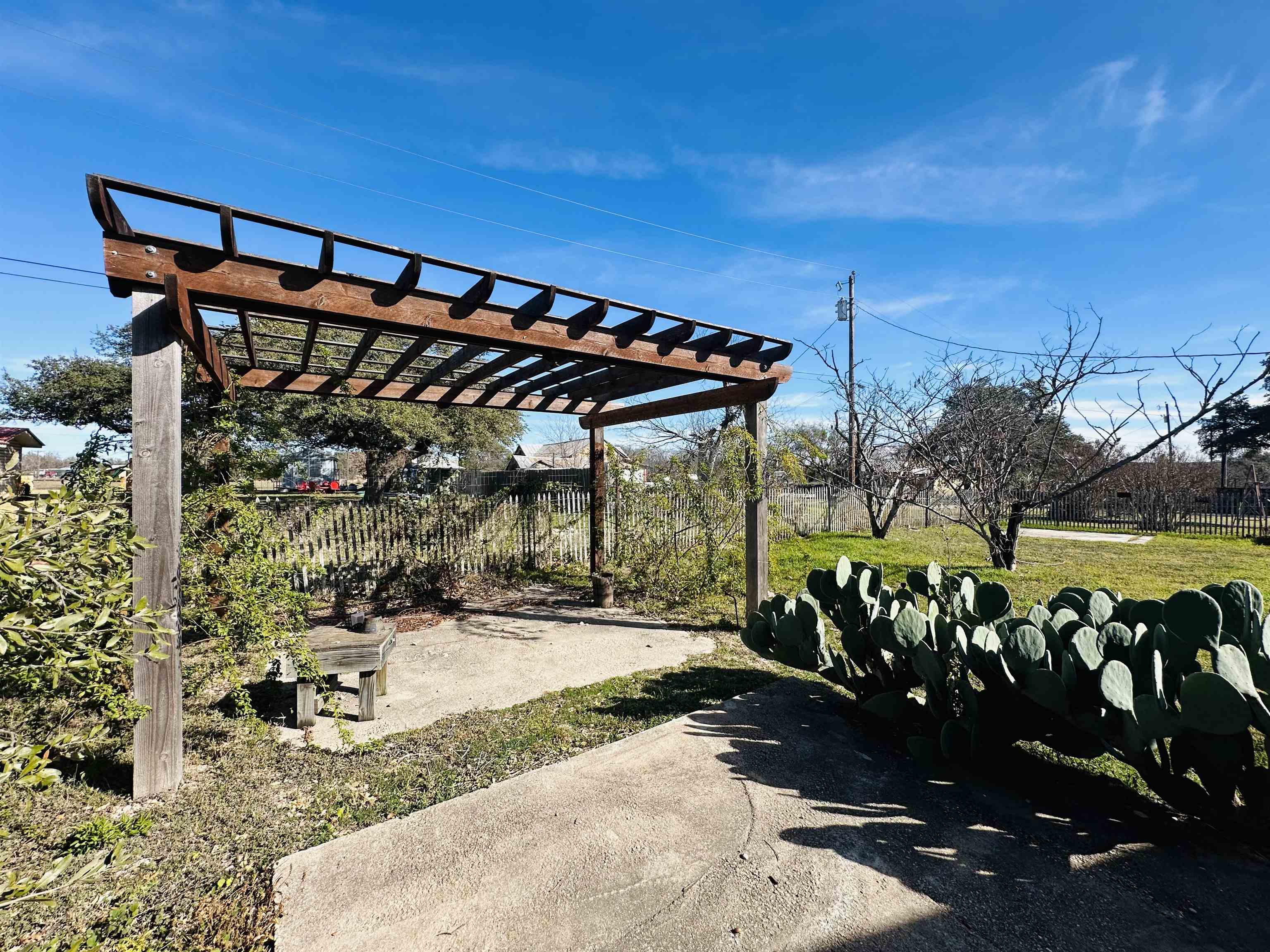 505 4th Street Lometa, TX 76853 - Photo 24 of 27 a view of a patio with table and chairs under an umbrella with palm trees