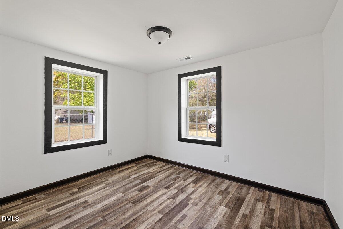 601 Temple Street Selma, NC 27576 - Photo 5 of 13 a view of an empty room with wooden floor and a window