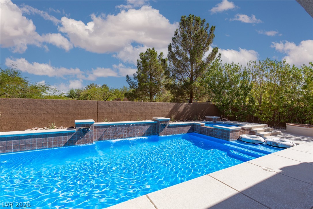 22 Douglas Grove Road Henderson, NV 89052 - Photo 63 of 72 A tranquil backyard oasis offers a pristine inground pool with cascading water features and an integrated spa.