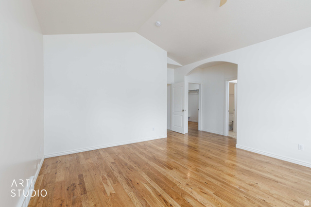 2327 Bluff Ridge Drive Syracuse, UT 84075 - Photo 22 of 66 Spacious room featuring wood flooring, vaulted ceiling, white baseboards, and a wide arched doorway
