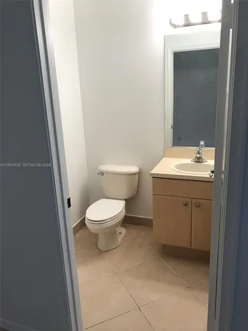 a view of an empty room with closet and wooden floor