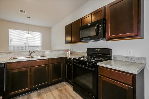 a kitchen with stainless steel appliances a stove a sink and a microwave