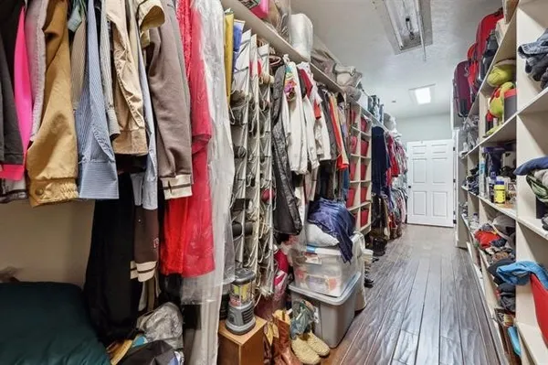 a view of walk in closet with clothes and shoes