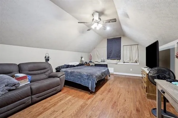 a spacious bedroom with a bed and a flat screen tv