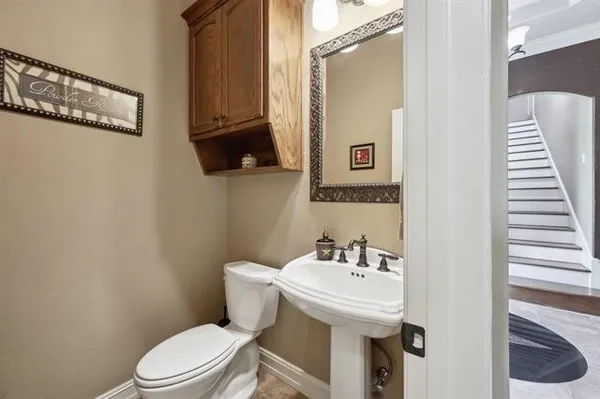 a bathroom with a sink a toilet and mirror