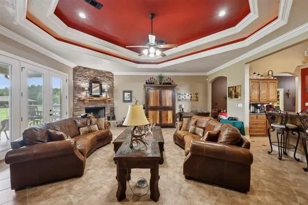 a living room with furniture a chandelier and a dining table with wooden floor