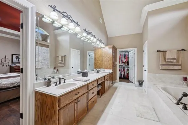 a spacious bathroom with a double vanity sink mirror and shower