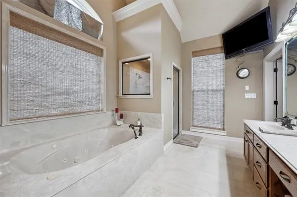 a spacious bathroom with a tub sink and mirror